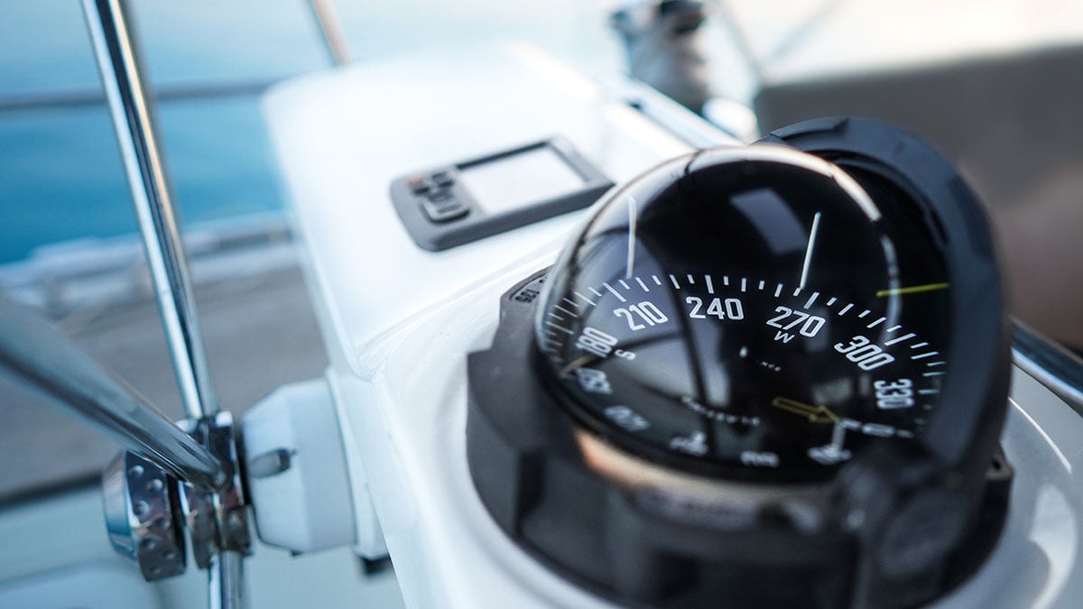 A close-up of a sailboat compass, representing leadership communication and staying aligned on direction